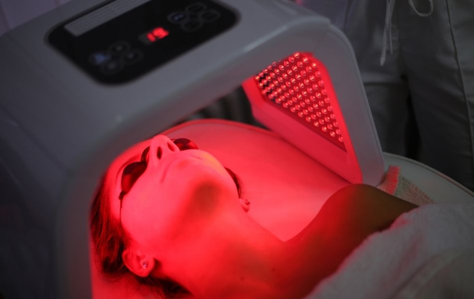 Woman getting light therapy treatment on her face